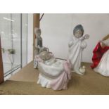 3 Lladro figurines - baby in cradle, child in bathrobe and lady with dove.