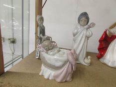 3 Lladro figurines - baby in cradle, child in bathrobe and lady with dove.