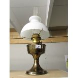 A brass oil lamp complete with shade and chimney.