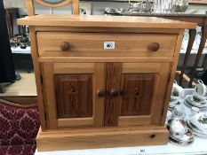 A solid pine cupboard with drawer