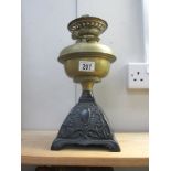 A Victorian oil lamp with brass font and cast iron base