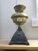 A Victorian oil lamp with brass font and cast iron base