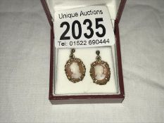 A pair of vintage cameo ear pendants in gold of female profiles