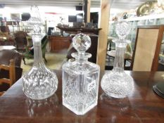 3 cut glass decanters including one etched.