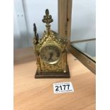 An early 20th century Gothic style small brass mantle clock