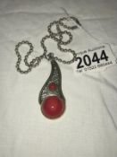 A red stone pendant and chain in silver
