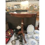 A dark wood stained tripod tea table with decorated top