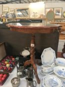 A dark wood stained tripod tea table with decorated top