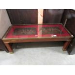 A mahogany and brass coffee table featuring 2 panels under glass depicting medieval knights.