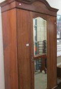 An Edwardian inlaid single mirror door wardrobe.
