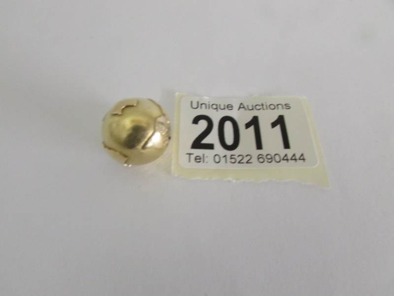 A 9ct gold charm in the form of a world globe, approximately 6 grams.