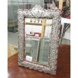 An ornate silver framed mirror.