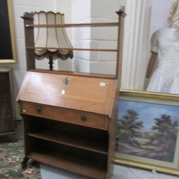 An oak arts and crafts bureau with book shelves atop.