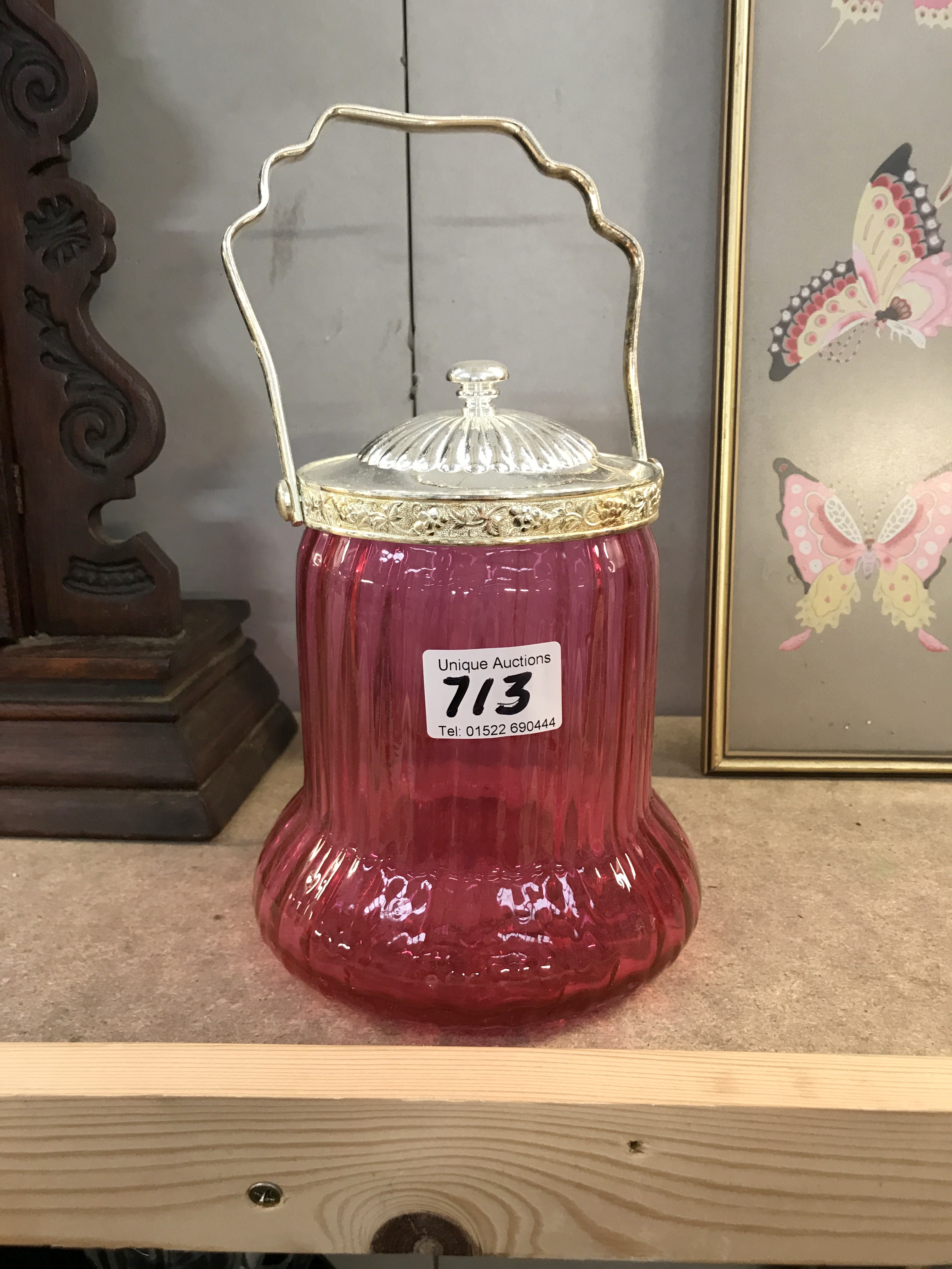 A cranberry glass biscuit barrel with silver plated fittings