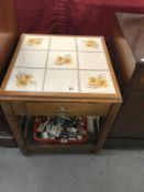 A tile topped oak side table with drawer