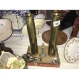 A mixed lot including brass shell cases, vintage handcuffs,