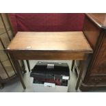 An Edwardian mahogany fold over card table with cross banded top