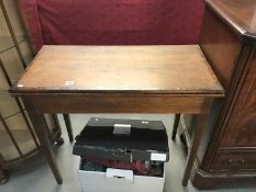 An Edwardian mahogany fold over card table with cross banded top