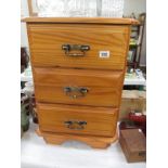 A 3 drawer dark stained pine chest of drawers