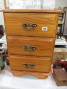 A 3 drawer dark stained pine chest of drawers