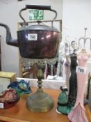 A copper kettle and a brass stand