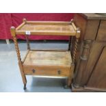 A two tier wooden trolley with drawer and barley twist sides