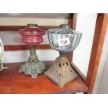 A Victorian cranberry glass oil lamp and 1 other - both missing burners