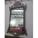 An ornate wooden wall mirror