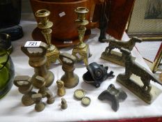 A pair of Victorian brass candlesticks, dog bookends, brass weights etc.