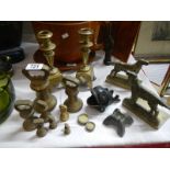 A pair of Victorian brass candlesticks, dog bookends, brass weights etc.