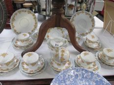 Approximately 32 pieces of teaware featuring yellow floral design