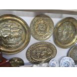 A quantity of brass chargers and wall plates
