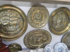 A quantity of brass chargers and wall plates