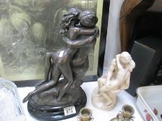 A large sculpture of a couple kissing and a sculpture of The Kiss