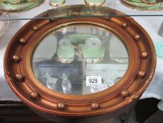 A gold coloured porthole mirror