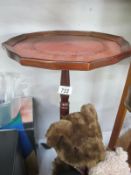 A dark wood stained tripod wine table with leather top