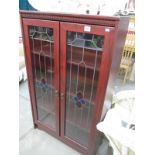 A glazed cabinet with leaded style doors