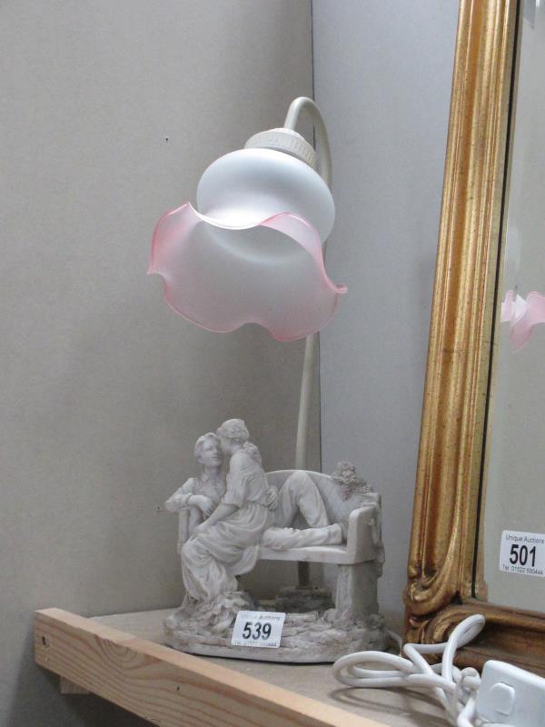 A figural table lamp featuring a couple