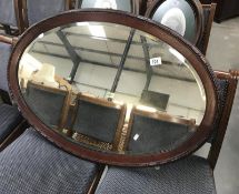 A large oval framed bevelled mirror