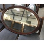 A large oval framed bevelled mirror