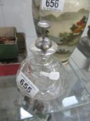 A perfume bottle with silver top