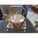 A Victorian copper kettle on brass trivet