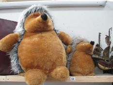 A larger hedgehog cuddly toy and a smaller example