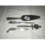 A pair of advertising letter openers, one other and a silver handled cake knife.
