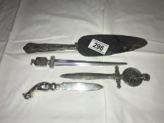 A pair of advertising letter openers, one other and a silver handled cake knife.