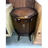 A dark wood stained octagonal drinks cabinet with leather inset top