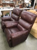 A pair of brown leather recliner chairs