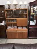 A 1970's teak wall unit with smoke glass doors