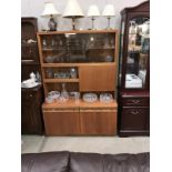 A 1970's teak wall unit with smoke glass doors