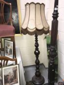 A turned dark wood stained standard lamp with shade.